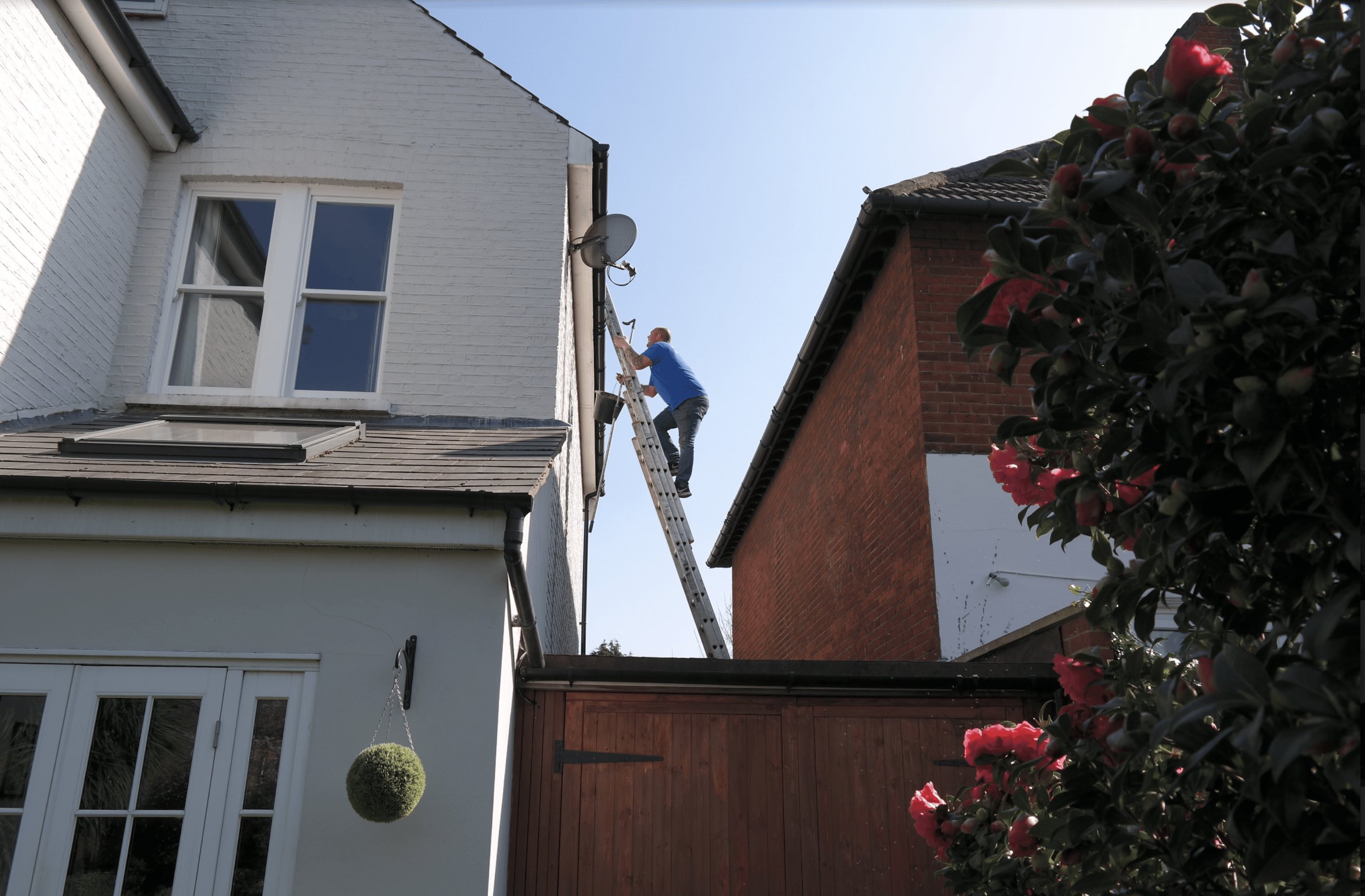 Man climbing ladder do a gutter repair in London