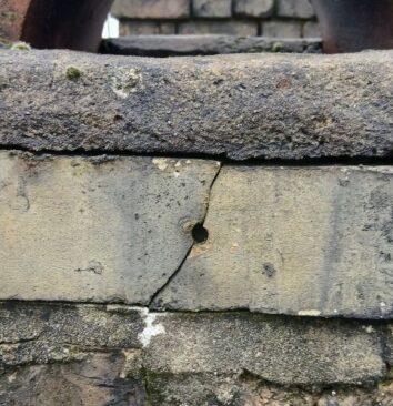 A hole and crack in a brick.