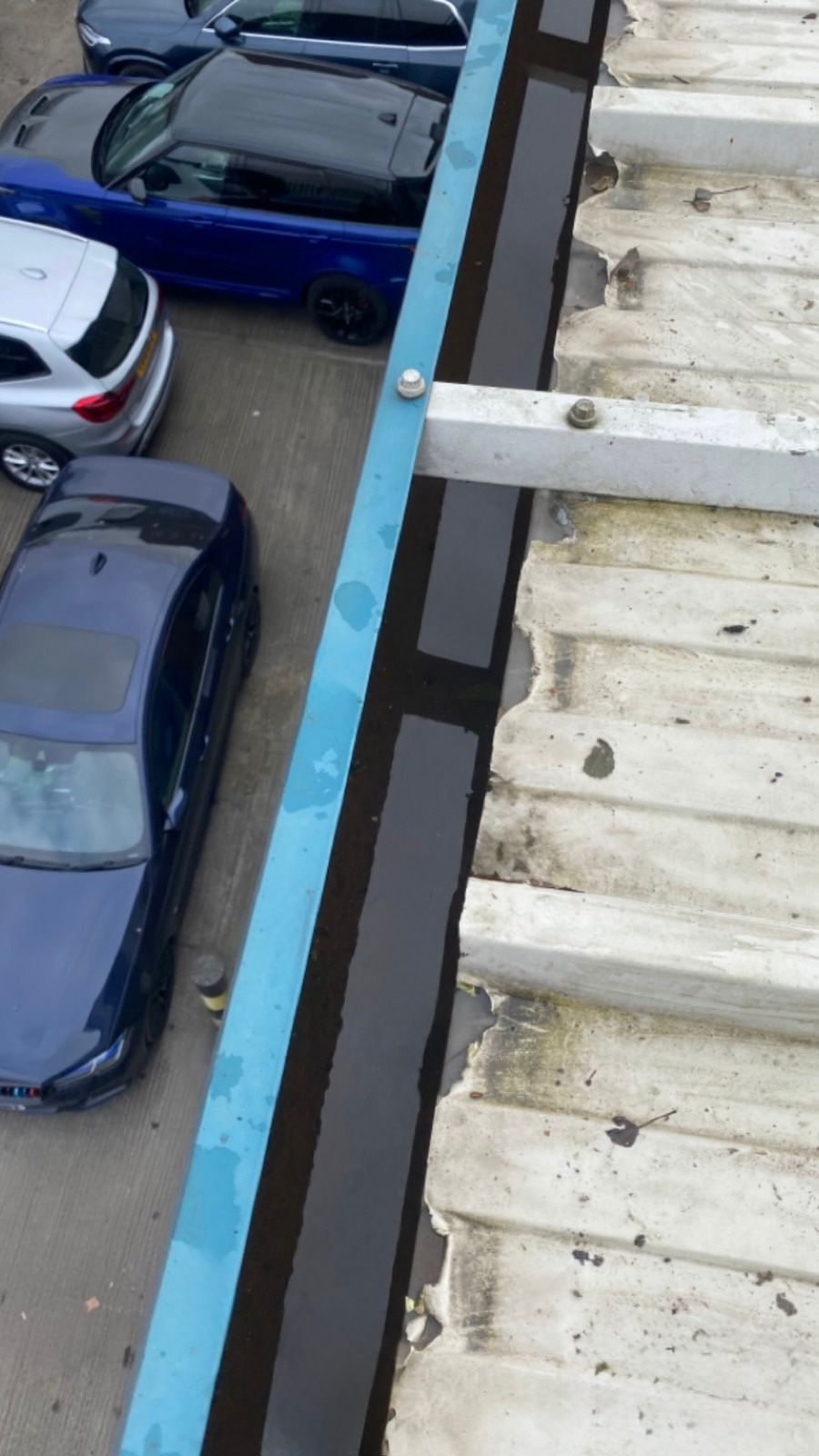 An after photo of a gutter that has been cleared of leaves on an industrial building.