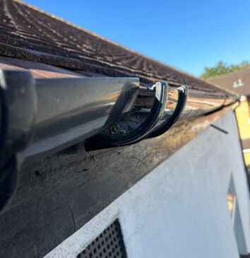 A black UPVC downpipe union that needs to be repaired.