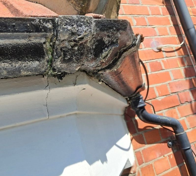 An old corner joint on a black UPVC gutter that needs replacing.