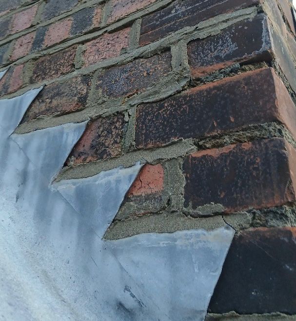 Pointing that is cracked and missing from a chimney stack.