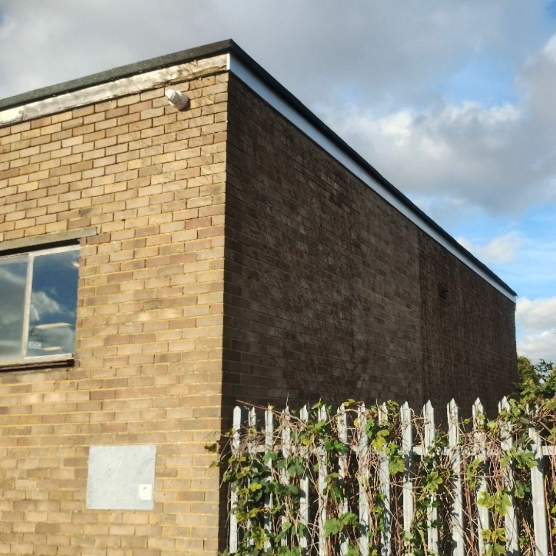 Showing one old fascia board and one new fascia board on a brick property.