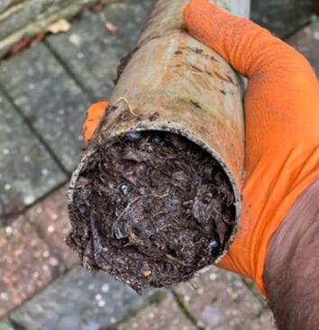 Shows a blocked downpipe.