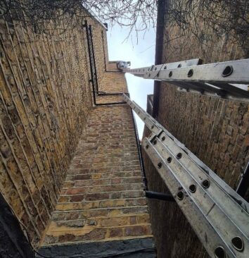 A ladder leaning against a 4 storey building.