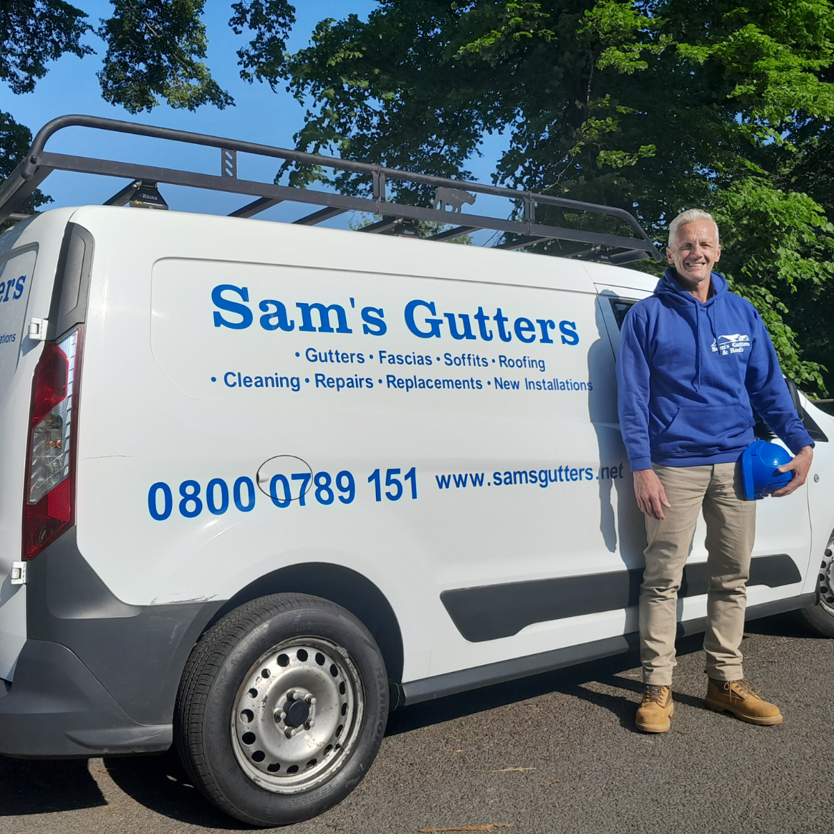 Showing gentleman standing next to white Sam's Gutters van, holding a blue hard hat.