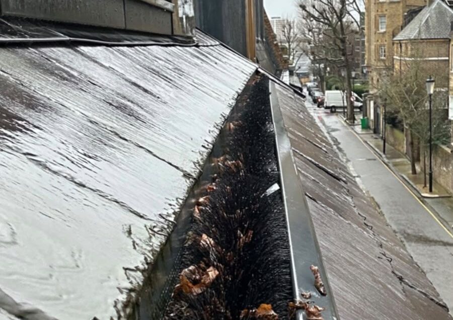 Photo of a commercial roof with blocked gutters.